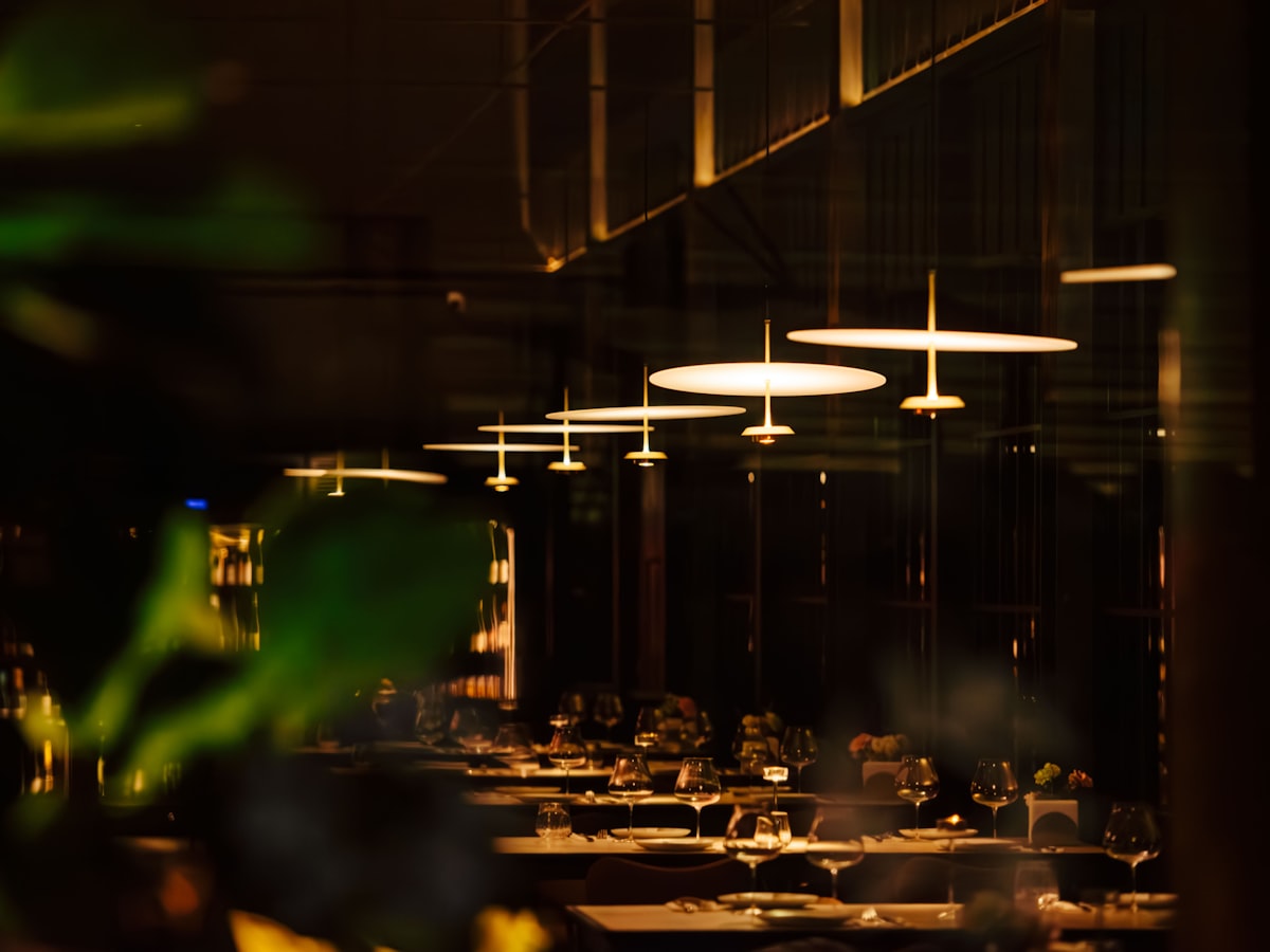 Warm pendant lighting over laid tables in the Saffron & Ember dining room