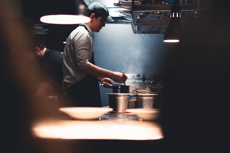 Chef preparing food in a busy restaurant kitchen