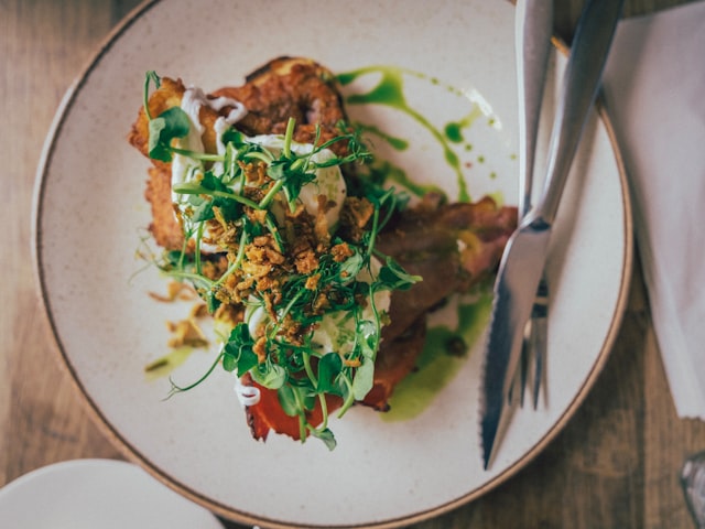 Savoury dish with greens and sauce on a white plate