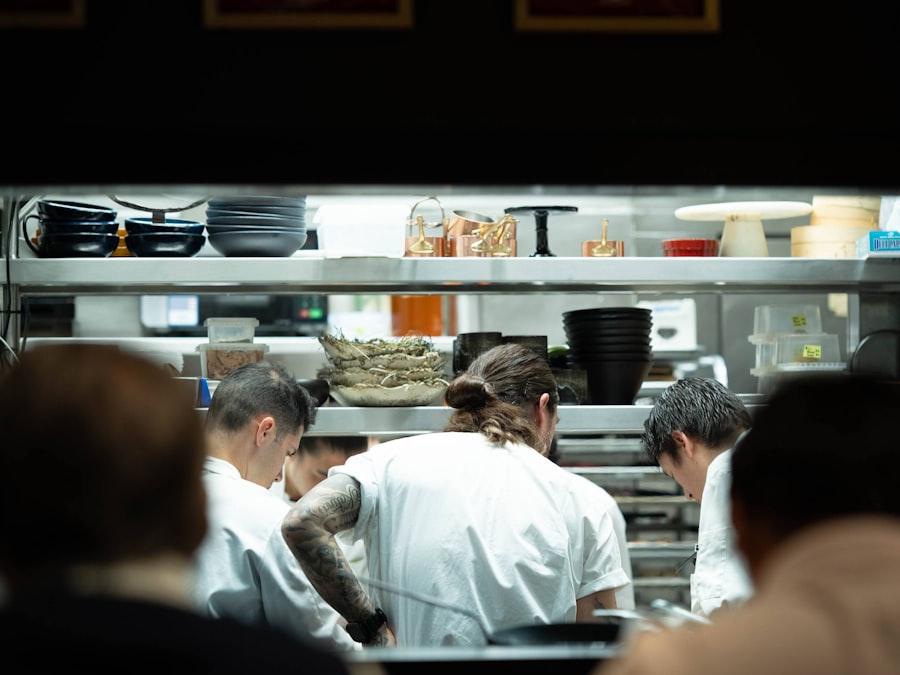Chefs working at the pass in a busy restaurant kitchen