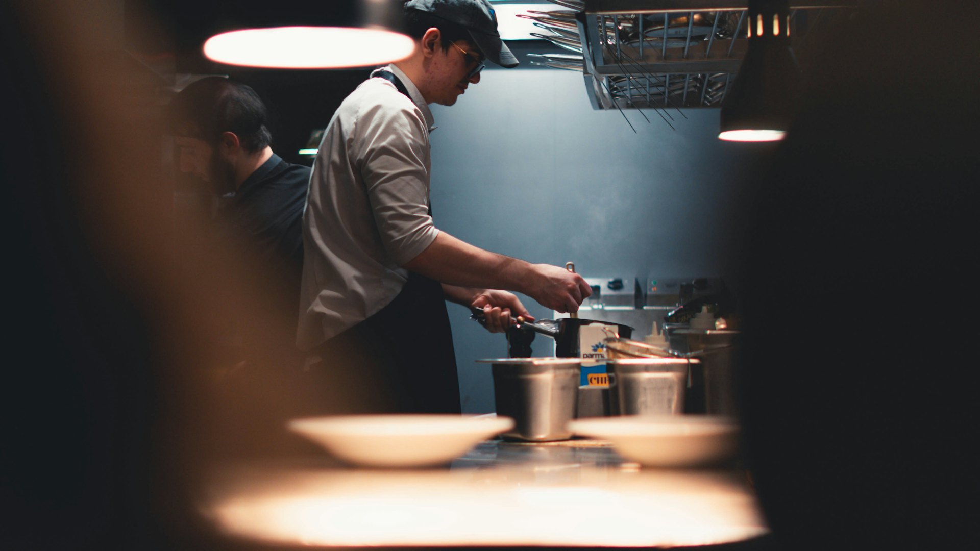 Chef plating a dish at the pass in the Saffron & Ember kitchen